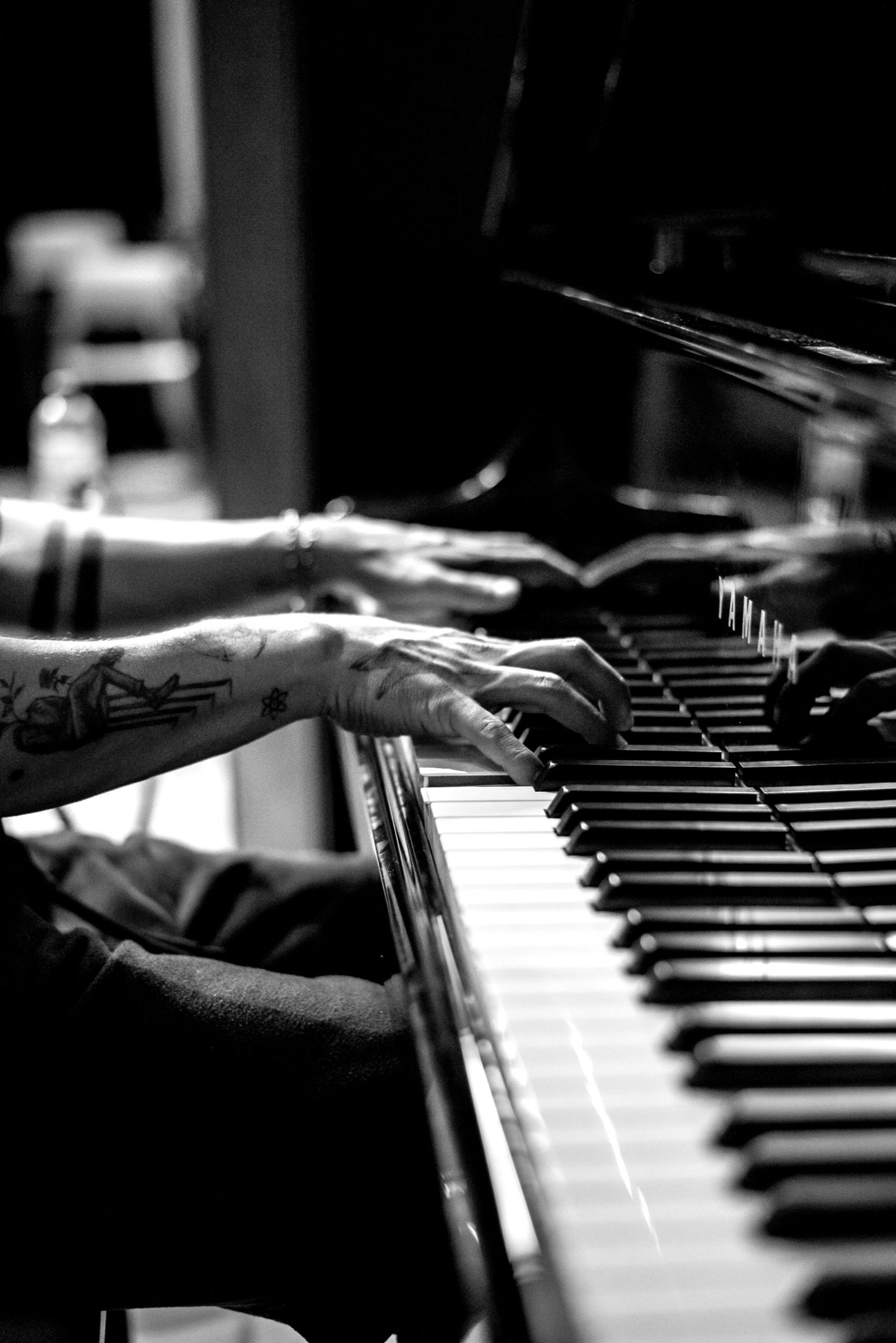 Mãos de pianista tocando piano, em preto e branco